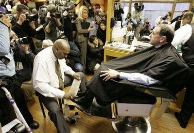 Paul Sancya/AP.  Monday, Dec. 31, 2007. Des Moines, Iowa.  via YahooNew.  caption: Republican presidential hopeful former Arkansas Gov. Mike Huckabee has his boots shined by James Reasby Jr. during a stop for a haircut at the Executive Forum Barbershop.