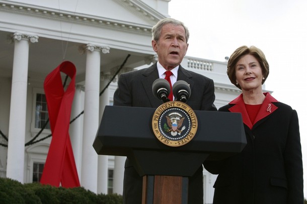 U.S. President George W. Bush speaks alongside a giant red AIDS ribbon on the occasion of World AIDS day with first lady Laura Bush on the North Lawn of the White House in Washington December 1, 2008.   REUTERS/Jason Reed   (UNITED STATES)