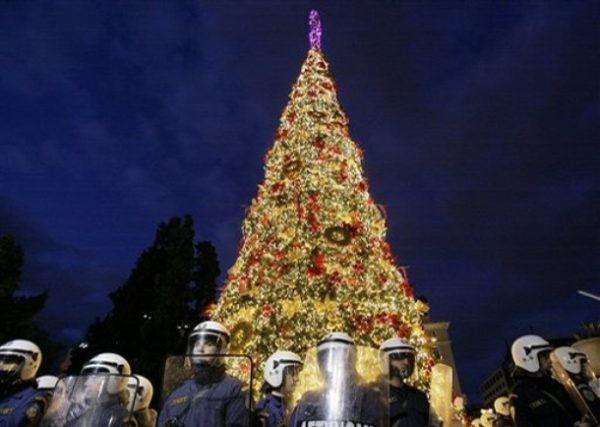 Riot police officers protect the Christmas tree during a protest in central Athens' Syntagma Square , Saturday, Dec. 20, 2008. A crowd of about of 150 clashed with dozens of riot police when they threw garbage at a tall Christmas tree and hung trash bags from the tree branches. The original tree was burned by protesters in the first days of the violence, following the Dec. 6 shooting of a 15 - year old teenager. (AP Photo / Petros Karadjias)