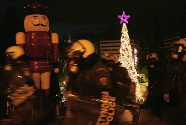Riot police officers protect the Christmas tree during a protest in central Athens' Syntagma Square , Saturday, Dec. 20, 2008. A crowd of about of 150 clashed with dozens of riot police when they threw garbage at a tall Christmas tree and hung trash bags from the tree branches. The original tree was burned by protesters in the first days of the violence, following the Dec. 6 shooting of a 15-year old teenager. (AP Photo/Petros Giannakouris)