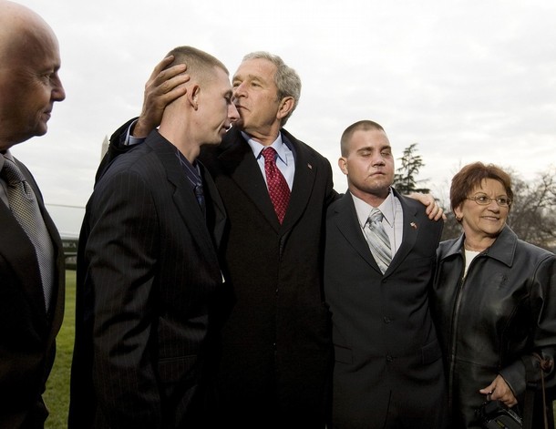 U.S. President George W. Bush (C) visits with two U.S. Marines wounded during a suicide bomber attack in Iraq after arriving back at the White House in Washington, December 9, 2008. From left are Patrick Paul Pittman Sr., his son, Lance Corporal Patrick Paul Pittman, Jr. of Savannah, Georgia, Bush, Lance Corporal Marc Olson of Coal City, Illinois, and his mother, Pinky Kloski. REUTERS/Larry Downing  (UNITED STATES)