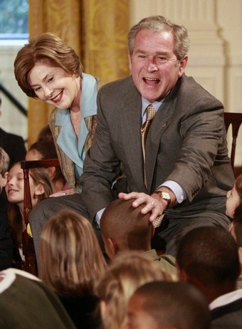 U.S. President George W. Bush and first lady Laura Bush gather with the children of military families as they attend a children's holiday reception in the East Room of the White House in Washington December 8, 2008.  REUTERS/Jason Reed   (UNITED STATES)