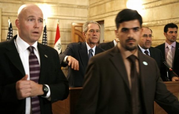 Security personnel surround U.S. President George W. Bush (C) after a man threw a shoe at him during a joint statement with Iraqi Prime Minister Nouri al-Maliki (2nd R) in Baghdad, December 14, 2008. REUTERS/Kevin Lamarque (IRAQ) REUTERS