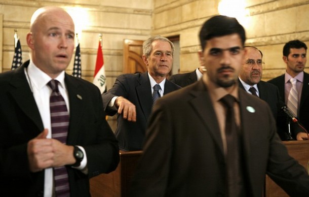 Security personnel surround U.S. President George W. Bush (C) after a man threw a shoe at him during a joint statement with Iraqi Prime Minister Nouri al-Maliki (2nd R) in Baghdad, December 14, 2008.     REUTERS/Kevin Lamarque   (IRAQ) REUTERS