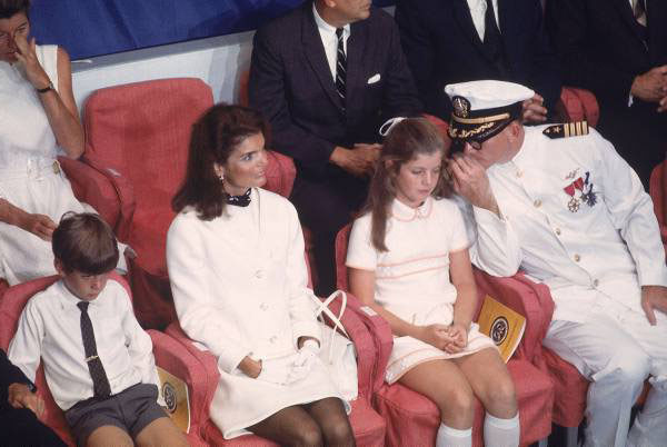 Charles H. Phillips. May 27, 1967. September 7, 1968. caption: Jacqueline Kennedy (2R) sitting with daughter Caroline (2L) & son John Jr. (R) at ceremonies for commissioning of the Navy aircraft carrier USS John F. Kennedy, with dignitaries & other members of the Kennedy family.