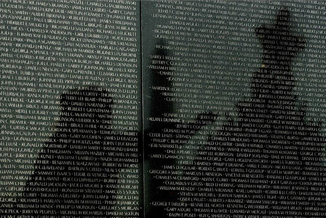 Kevin Lamarque/Reuters. caption: Reflected on the wall listing in the names of American soldiers who died in the Vietnam War, a veteran helps decorate the Christamas tree placed at the Vietnam War Memorial in Washington December 23, 2008