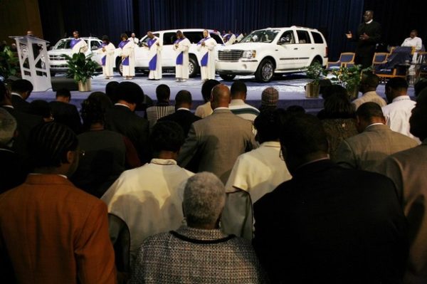 People pray for the future of the American auto industry during a special service called "A Hybrid Hope" at the Greater Grace Temple in Detroit, Michigan December 7, 2008. White House and congressional negotiators sought on Sunday to remove remaining differences over an emergency rescue for the U.S. auto industry, a wounded giant of the struggling American economy. REUTERS/Carlos Barria (UNITED STATES)