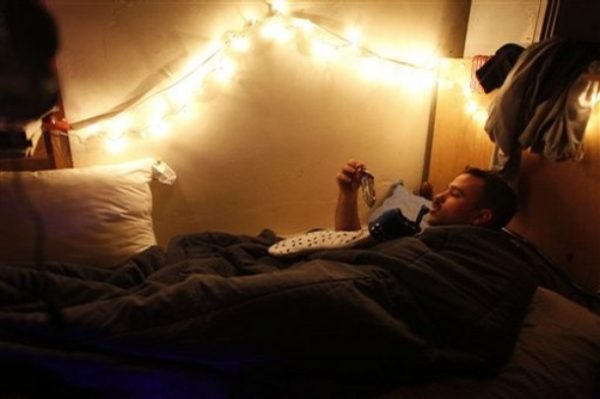 U.S. Army Spc. Hugo Esteves of C company, 1-68 Armor, 2 BCT, 4th Infantry Division opens his Christmas present at combat outpost Ford in the Shiite stronghold of Sadr City in Baghdad, Iraq, on Christmas morning Thursday, Dec. 25 2008. (AP Photo/Dusan Vranic)