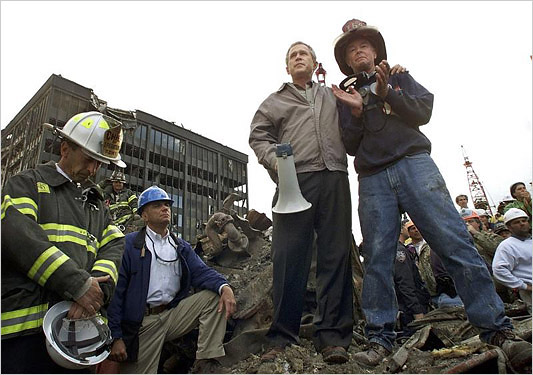 image: Win McNamee: caption: U.S. President George W. Bush talks to retired firefighter Bob Beckwith (R) from Ladder 117 at the scene of the World Trade Center disaster in New York, September 14, 2001