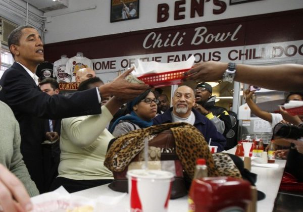 U.S. President-elect Barack Obama (L) picks up his food order at the counter of Ben's Chili Bowl Restaurant in
