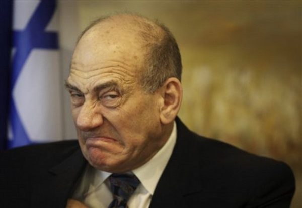 Israeli Prime Minister Ehud Olmert reacts as he adjusts his shirt during a meeting with US Congress members at the Knesset, Israel's parliament, in Jerusalem, Monday, Feb. 18, 2008. Israeli Prime Minister Ehud Olmert gave his military a "free hand" to hit Gaza militants after a rocket slammed into a house in an Israeli town following a visit there by the new U.N. humanitarian chief, who called for an end to the daily salvos.(AP Photo/Dan Balilty)