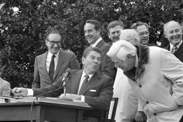 ** FILE ** In this April 20, 1983 file photo, House Speaker Thomas "Tip" O'Neill, right, leans forward to ask President Ronald Reagan a question during the Social Security bill signing ceremony on the South Lawn of the White House. A reader-submitted question about Social Security taxation is being answered as part of an Associated Press Q&A column called "Ask AP." Also pictured, from left: economist Alan Greenspan, head of the president's Social Security task force; Sen. Bob Dole, R-Kan.; Reagan; Rep. Dan Rostenkowski, D-Ill.; Rep. Claude Pepper, D-Fla. partially obscured; Rep. Bob Michel, R-Ill. (AP Photo/Barry Thumma, File)