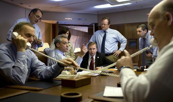 National Security Advisor General James Jones, left, and United States Secret Service Special Agent in Charge Joe Clancy, right, are seen aborad Air Force One flying to Iraq April 7, 2009, as they coordinate arrival details by telephone for President Barack Obama's visit to Baghdad. Joined also by White House Senior Advisor David Axelrod; Chief of Staff Rahm Emanuel; Presidential Scheduler Alyssa Mastromonaco; Jim Messina, Deputy Chief of Staff; White House Press Secretary Robert Gibbs, and National Security Council Chief of Staff Mark Lippert, background-right. White House Photo/ Pete Souza