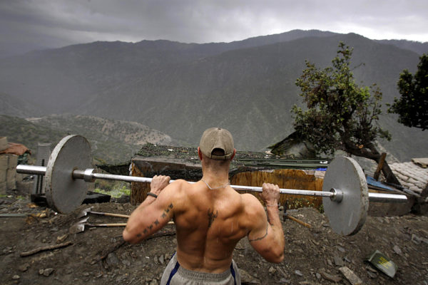 Spl. Taylor Jordan from the U.S. Army First Battalion, 26th Infantry lifts weights in the rain at his platoon's base Camp Restrepo in the Korengal Valley in Afghanistan's Kunar Province on Friday May 8, 2009.  (AP Photo/David Guttenfelder)