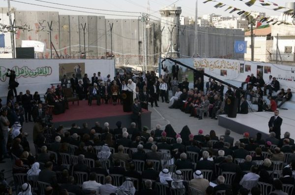 Pope Benedict XVI speaks during his visit to the Aida refugee camp, with the Israeli separation barrier in the background, near the West Bank city of Bethlehem on May 13, 2009. Pope Benedict XVI called for a Palestinian homeland, urged youths to shun "terrorism" and lamented Israel's wall that towered over his first trip to the West Bank. AFP PHOTO / AHMAD GHARABLI (Photo credit should read AHMAD GHARABLI/AFP/Getty Images)