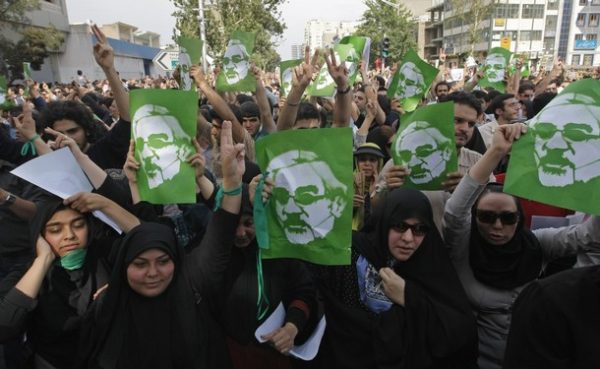 Iranian opposition demonstrators carry portraits of defeated reformist presidential candidate Mir Hossein Mousavi, in Tehran on June 15, 2009. Opposition supporters defied a ban to stage a mass rally in Tehran in protest at President Mahmoud Ahmadinejad's landslide election win, as Iran faced a growing international backlash over the validity of the election and the subsequent crackdown on opposition protests. AFP PHOTO/BEHROUZ MEHRI (Photo credit should read BEHROUZ MEHRI/AFP/Getty Images)