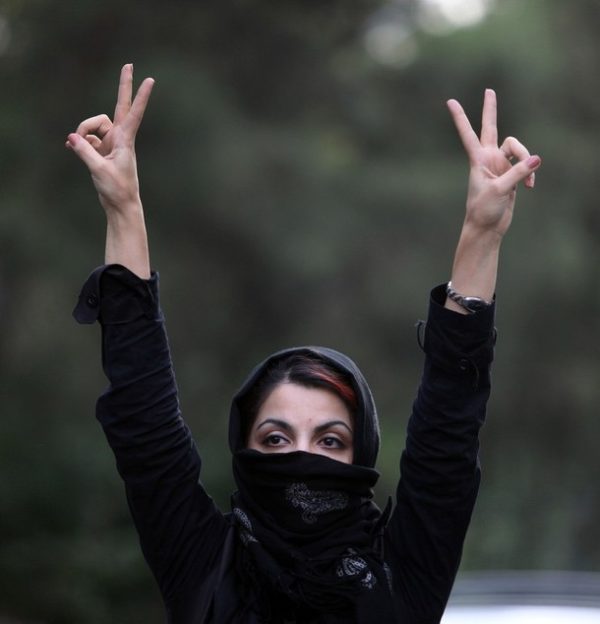 TEHRAN, IRAN - JULY 9: An Iranian woman holds her hands in the air and makes V signs as she protests in the streets on July 9, 2009 in Tehran, Iran. Following the recently disputed presidential elections demonstrators were met by force and tear gas rounds fired by Iranian police and Basij as they defyied government warnings to stage a march in commeration of the anniversary of bloody student unrest in 1999 at Tehran University. (Photo by Getty Images)