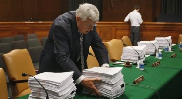 Sen. Mike Enzi, R-Wyo., the ranking Republican on the Senate Health, Education, Labor and Pensions Committee moves copies of the health care reform bill and its amendments before are markup hearing on Capitol Hill in Washington, Wednesday, June 17, 2009. (AP Photo/Charles Dharapak)