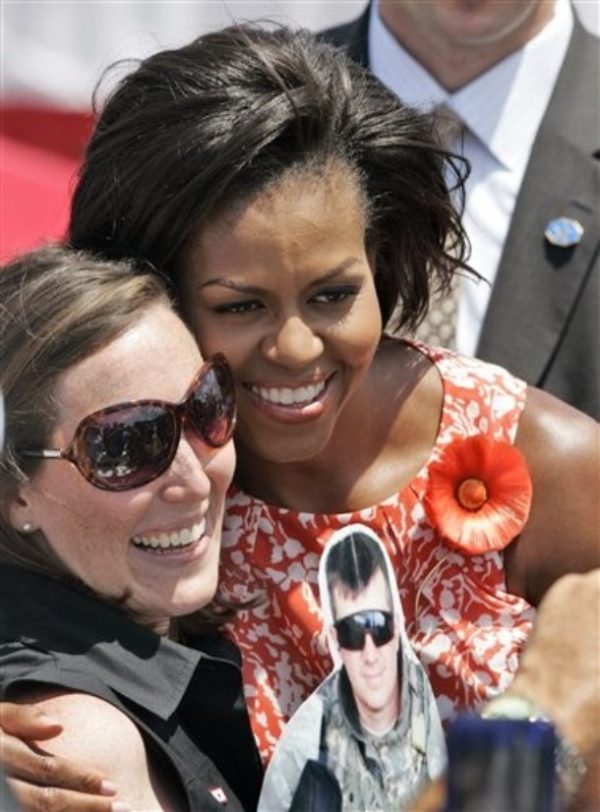 First Lady Michelle Obama, right, poses with Vivian Greentree, as she holds a photo of her husband, Mike Greentree, who is deployed in Iraq, during a visit to the Norfolk Naval Station in Norfolk, Va., Friday, July 31, 2009.  Mrs. Obama was in town to address the sailors returning from the USS Eisenhower and US Comfort battle group. (AP Photo/Steve Helber)