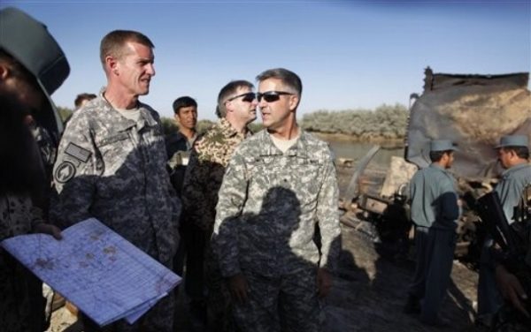 U.S Gen. Stanley McChrystal, left, commander of US and Nato forces in Afghanistan and U.S. Rear Admiral Gregory J. Smith, center, NATO's director of communications in Kabul, are surrounded by Afghan and German soldiers as they visit the site where villagers reportedly died when American jets bombed fuel tankers hijacked by the Taliban, outside Kunduz, Afghanistan, Saturday, Sept. 5, 2009. The top U.S. and NATO commander in Afghanistan visited the site as the alliance began an investigation into the airstrike that killed up to 70 people. (AP Photo/Anja Niedringhaus)