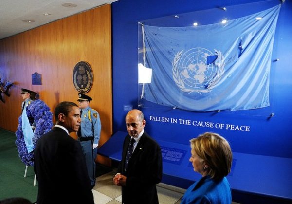 NEW YORK - SEPTEMBER 23: U.S. President Barack Obama (L) stands with Ahmad Fawzi (2nd R), who was the UN spokesman in Baghdad and now director of news and media at the UN, and U.S. Secretary of State Hillary Clinton in front of a flag from the bombed Canal Hotel in Baghdad, during a wreath laying ceremony for fallen United Nations staff members at U.N. headquarters September 23, 2009 in New York City.Obama is in New York to attend the 64th United Nations General Assembly. (Photo by Olivier Douliery-Pool/Getty Images)