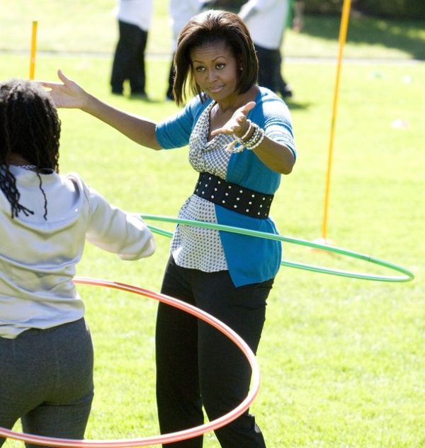 U.S. first lady Michelle Obama tries to hula hoop with children at the White House Healthy Kids Fair on the South Lawn in Washington, October 21, 2009. REUTERS/Larry Downing (UNITED STATES POLITICS)