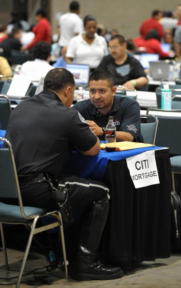 Homeowners (left side of table) meet with bank representatives (right side of table) in the hopes of renegotiating their mortgage payments and saving their home from the possibility of foreclosure at an event organized by the non-profit organization Neighborhood Assistance Corporation of America (NACA)  at the Los Angeles Convention Center on September 28, 2009. NACA provides the opportunity for borrowers to meet with counselors and bank representatives on the spot to renegotiate their loan terms.         AFP PHOTO/ROBYN BECK (Photo credit should read ROBYN BECK/AFP/Getty Images)