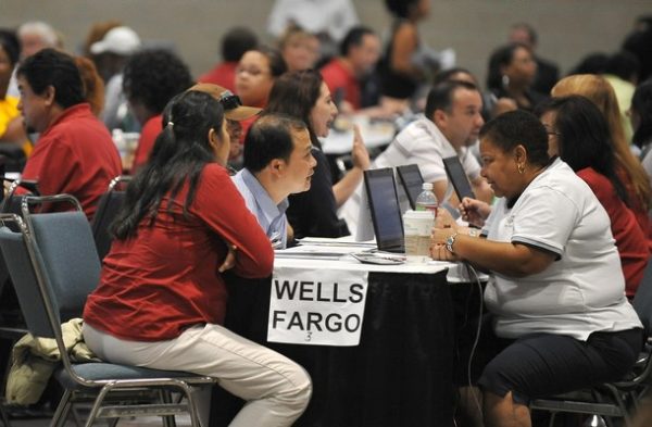 Homeowners (left side of table) meet with bank representatives (right side of table) in the hopes of renegotiating their mortgage payments and saving their home from the possibility of foreclosure at an event organized by the non-profit organization Neighborhood Assistance Corporation of America (NACA) at the Los Angeles Convention Center on September 28, 2009. NACA provides the opportunity for borrowers to meet with counselors and bank representatives on the spot to renegotiate their loan terms. AFP PHOTO/ROBYN BECK (Photo credit should read ROBYN BECK/AFP/Getty Images)