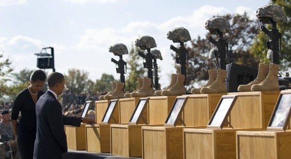 US President Barack Obama and First Lady Michelle Obama pay their respects to the fallen soldiers and civilians at Ill Corps Headquarters at Fort Hood Army Base on November 10, 2009 during a memorial service for the soldiers and civilians killed in a shooting rampage on November 5. AFP PHOTO/Jim WATSON (Photo credit should read JIM WATSON/AFP/Getty Images)