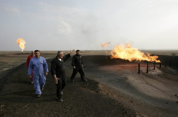Workers walk at Fakka oilfield, near Amara, 300 km (185 miles) southeast of Baghdad, December 8, 2009. Deal makers from the world's largest energy firms assembled amid tight security at Iraq's Oil Ministry on Friday to compete for deals to develop some of the country's most prized oilfields. Picture taken December 8, 2009.  REUTERS/Atef Hassan (IRAQ ENERGY BUSINESS)