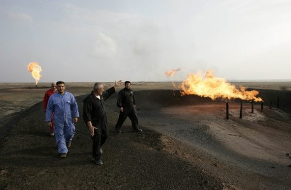 Workers walk at Fakka oilfield, near Amara, 300 km (185 miles) southeast of Baghdad, December 8, 2009. Deal makers from the world's largest energy firms assembled amid tight security at Iraq's Oil Ministry on Friday to compete for deals to develop some of the country's most prized oilfields. Picture taken December 8, 2009. REUTERS/Atef Hassan (IRAQ ENERGY BUSINESS)