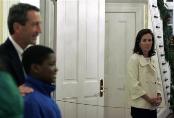 FILE - In a Thursday, Dec. 3, 2009 file photo, South Carolina first lady Jenny Sanford, right, looks on as her husband Gov. Mark Sanford, takes a photo with guests at the Governor's Mansion in Columbia, S.C., during a Christmas Open House. Jenny Sanford announced Friday, Dec. 11, 2009 that she has filed for divorce, months after her husband publicly confessed an affair with Maria Belen Chapur. (AP Photo/Brett Flashnick, File)