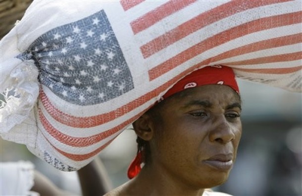 A woman carries a bag containing rice donated by the United States Agency for International Development, USAID, as she walks through a market in Leogane, Haiti  Saturday, Jan. 16, 2010. A powerful earthquake hit Haiti on Tuesday. (AP Photo/Lynne Sladky)