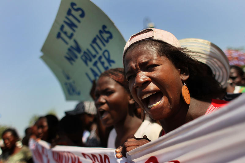 PORT-AU-PRINCE, HAITI - FEBRUARY 09: Women chant while marching for more earthquake relief aid on February 9, 2010 in Port-au-Prince, Haiti. While aid has been pouring into Haiti's capitol, thousands of people left homeless by the devastating earthquake on January 12 have yet to receive tents and adequate food. (Photo by John Moore/Getty Images)