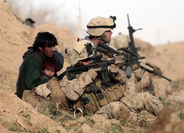 U.S. Marines from Bravo Company, 1st Battalion, 6th Marines, protect an Afghan man and his child after Taliban fighters opened fire in the town of Marjah, in Nad Ali district, Helmand province, February 13, 2010. U.S.-led NATO troops launched a crucial offensive on Saturday against the Taliban's last big stronghold in Afghanistan's most violent province and were quickly thrown into a firefight with the militants. REUTERS/Goran Tomasevic (AFGHANISTAN - Tags: CIVIL UNREST POLITICS CONFLICT)