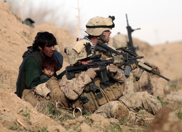 U.S. Marines from Bravo Company, 1st Battalion, 6th Marines, protect an Afghan man and his child after Taliban fighters opened fire in the town of Marjah, in Nad Ali district, Helmand province, February 13, 2010. U.S.-led NATO troops launched a crucial offensive on Saturday against the Taliban's last big stronghold in Afghanistan's most violent province and were quickly thrown into a firefight with the militants. REUTERS/Goran Tomasevic  (AFGHANISTAN - Tags: CIVIL UNREST POLITICS CONFLICT)