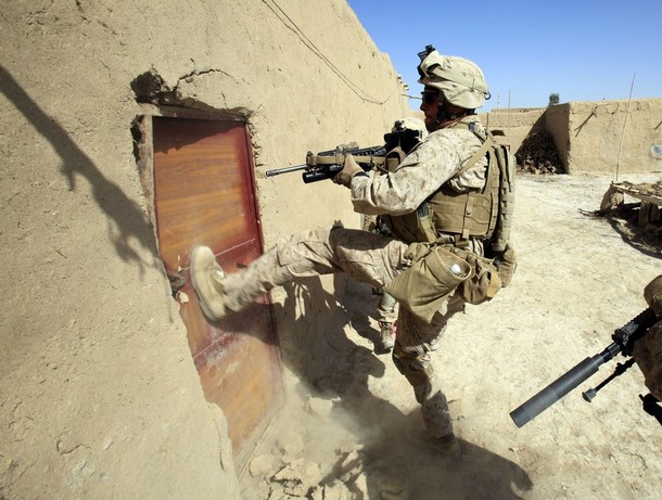 A U.S. Marine from Bravo Company of the 1st Battalion, 6th Marines breaks the door of a house to search for weapons during an operation in the town of Marjah, in Nad Ali district of Helmand province February 16, 2010. U.S. Marines, leading one of NATO's biggest offensives against Taliban Islamic militants in Afghanistan, are facing fierce resistance in some areas, bogged down by heavy gunfire, snipers and booby traps.  REUTERS/Goran Tomasevic  (AFGHANISTAN)