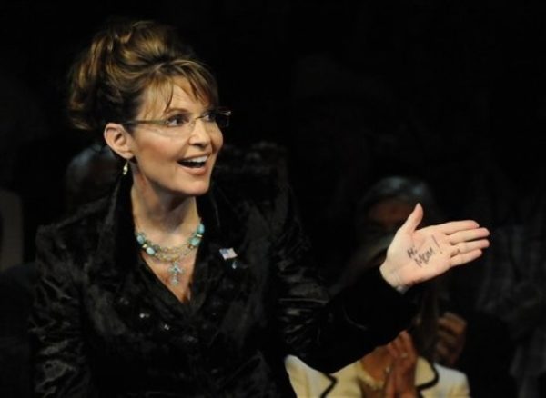 In this Feb. 7, 2010 photo, former Alaska Gov. Sarah Palin sends a message to her mother, written on her left hand, at a campaign rally for Texas Gov. Rick Perry in Cypress, Texas. (AP Photo/Pat Sullivan)