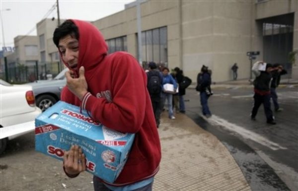 A man carries goods during looting in a supermarket in Concepcion, Chile, Sunday, Feb. 28, 2010. A 8.8-magnitude earthquake hit Chile early Saturday. (AP Photo/ Natacha Pisarenko)