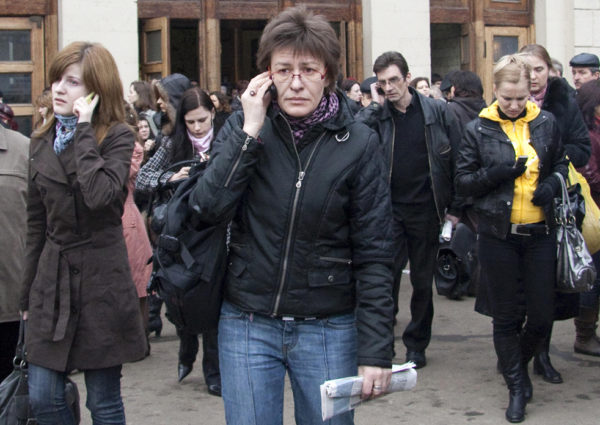 Commuters make cell phone calls while leaving the Park Kultury subway station that was hit by an explosion, in Moscow, Monday, March 29, 2010. Female suicide bombers blew themselves up Monday in twin attacks on Moscow subway stations packed with rush-hour passengers, killing many people and wounding several more, officials said. The carnage blamed on rebels from the Caucasus region follows the killings of several high-profile Islamic militant leaders there. (AP Photo/ Egor Barbatunov)