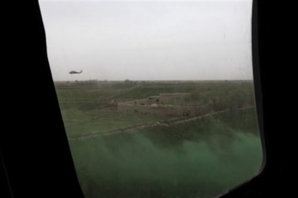 Green smoke marks the landing zone as seen through the plexiglass window of a quickly-decending U.S. Army Task Force Pegasus helicopter on a mission to evacuate a wounded U.S. Marine, in Marjah, Helmand province, Afghanistan, Tuesday March 2, 2010. The "chase" or security helicopter circles in the background. Pegasus crews provide the fast medical evacuation of seriously wounded combatants and civilians. (AP Photo/Brennan Linsley)