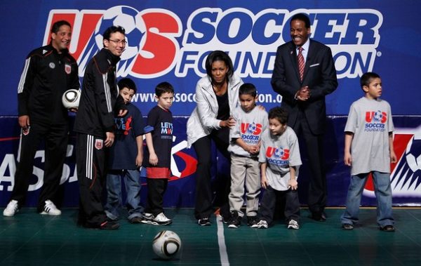 WASHINGTON - MARCH 05: U.S. first lady Michelle Obama (C) and US Soccer Foundation President and CEO Ed Foster-Simeon (R) participate with local school kids in a youth soccer clinic March 5, 2010 in Washington, DC. The clinic is to promote the national fight against childhood obesity and in support for the first lady's "Let's Move!" campaign that encourage children to get 60 minutes of active play each day. (Photo by Alex Wong/Getty Images)