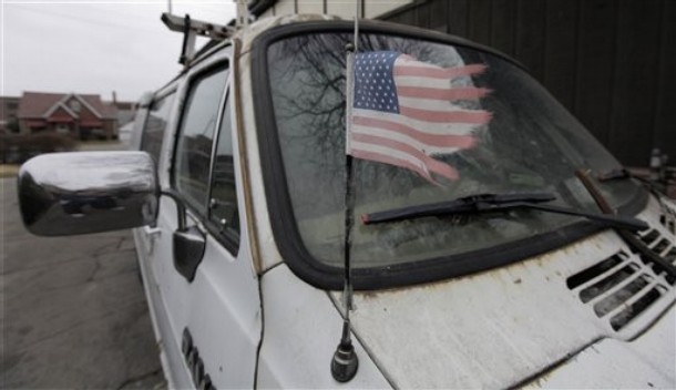 A tattered American flag is taped to the antenna of a van at the home of Thomas William Piatek Monday, March 29, 2010, in Whiting, Ind. Piatek is one of nine suspects tied to a Christian militia that was preparing for the Antichrist and are charged with conspiring to kill police officers, then attack a funeral using homemade bombs in the hopes of killing more law enforcement personnel, federal prosecutors said Monday. The Michigan-based group, called Hutaree, planned to use the attack on police as a catalyst for a larger uprising against the government, according to newly unsealed court papers. U.S. Attorney Barbara McQuade said agents moved on the group because its members were planning a violent mission sometime in April. (AP Photo/(M. Spencer Green)