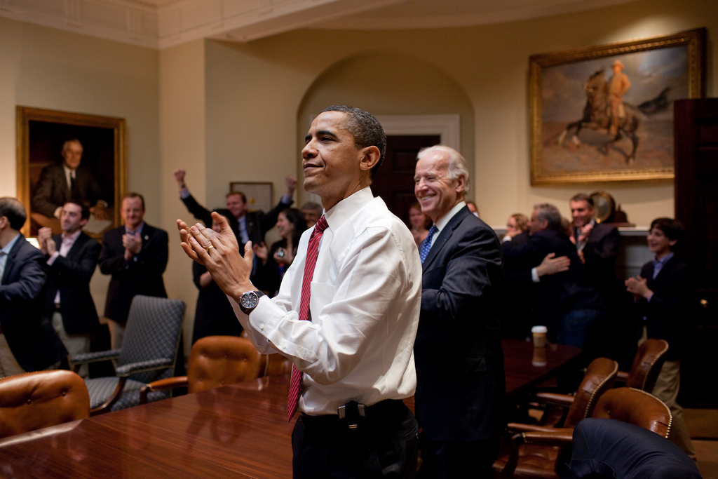 President Barack Obama, Vice President Joe Biden, and senior staff applaud in the Roosevelt Room of the White House, as the House passes the health care reform bill, March 21, 2010. (Official White House Photo by Pete Souza)  This official White House photograph is being made available only for publication by news organizations and/or for personal use printing by the subject(s) of the photograph. The photograph may not be manipulated in any way and may not be used in commercial or political materials, advertisements, emails, products, promotions that in any way suggests approval or endorsement of the President, the First Family, or the White House.