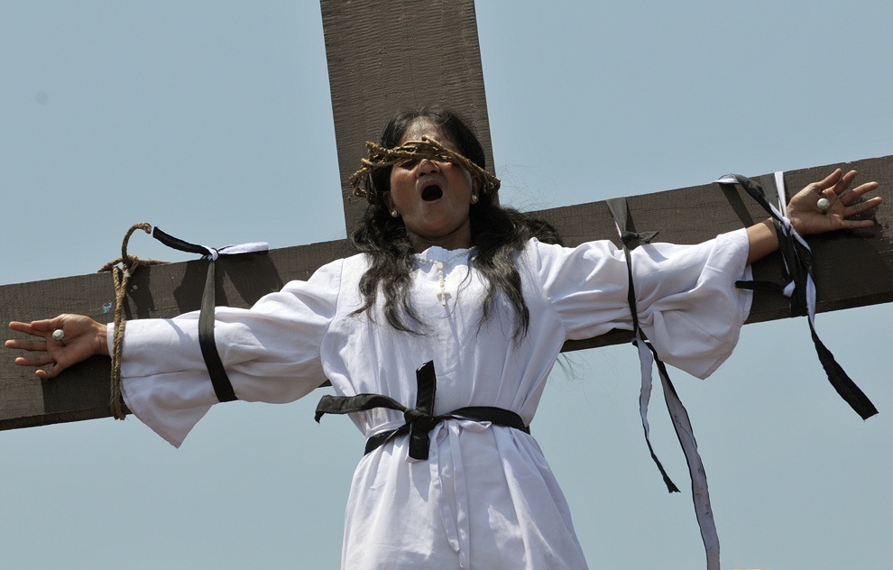 (photo: Jay Directo/Getty Images. caption: Filipina Roman Catholic Mary-Jane Mamangun is nailed to a cross as a re-enactment of the Crucifixion of Christ during Good Friday celebrations ahead of Easter in the village of San Juan, north of Manila, in The Philippines on April 2, 2010.)