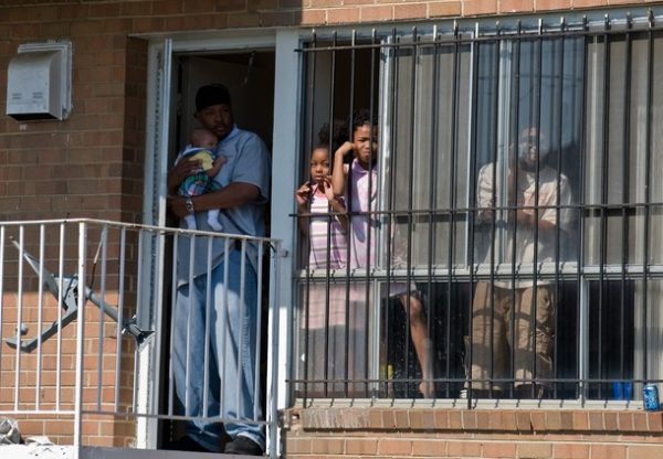 People watch out of the window of theor apatment as US President Barack Obama arrives to attend Easter services at Allen Chapel African Methodist Episcopal Church in Washington on April 4, 2010. AFP PHOTO/Nicholas KAMM (Photo credit should read NICHOLAS KAMM/AFP/Getty Images)