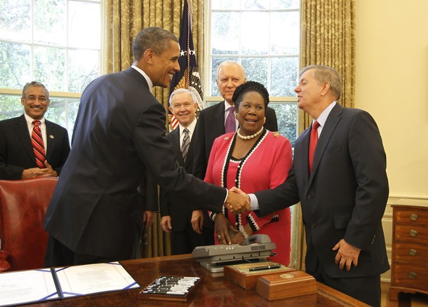 U.S. President Barack Obama shakes hands with U.S. Senator Lindsay Graham in Washington