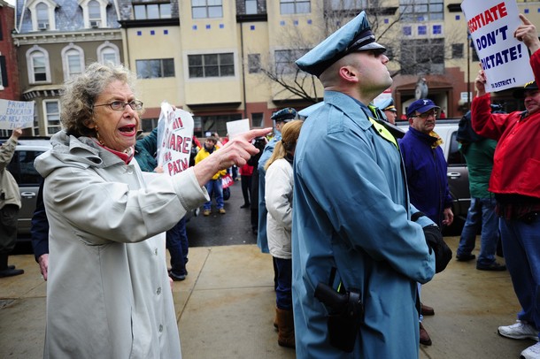 TEA party supporters (L) argues with Union members during a rally outside New Jersey���s Statehouse, calling for an end to Governor Chris Christie���s benefit cuts in what they see is a war on public workers, in Trenton, New Jersey, February 25, 2011.  Some 3,000 people gathered in the rain outside New Jersey���s Capitol to protest proposed benefit cuts and show support for workers fighting Wisconsin Governor Scott Walker���s bill to limit collective bargaining.AFP PHOTO/Emmanuel Dunand (Photo credit should read EMMANUEL DUNAND/AFP/Getty Images)