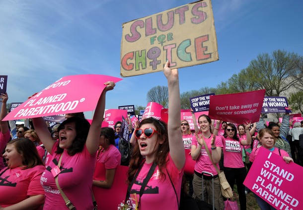 Participants shout slogans and display placards during a rally to "stand up for women's health" at the National Mall in Washington, DC, on April 7, 2011. Participants from across the country gathered in a show of support for Planned Parenthood, the family-planning group in the crosshairs of the budget battle blazing in Congress, where a federal shutdown is looming. AFP PHOTO/Jewel Samad (Photo credit should read JEWEL SAMAD/AFP/Getty Images)
