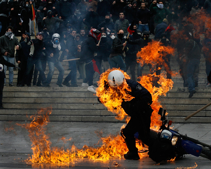 Moments after a fellow police officer rammed a protester with his motorbike, a riot policeman in flames tries to escape, after a petrol bomb was thrown on his helmet during riots in front of the Parliament in central Athens, Greece on 23 February 2011. During the year, Greece has been in the eye of this global economical storm. The immense Greek debt led the government to take immediate and cruel austerity measures targeting mostly the working middle class. Violence made its appearance in numerous protests in the Greek capital of Athens marked by clashes with riot police and left hundreds injured. This social unrest does not seem to calm down as there are no signs of a clear and optimistic future for the country and its people.